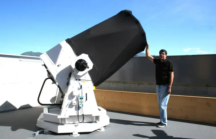José de Queiroz ao pé do telescópio que descobriu o asteroide